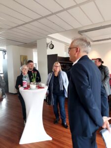 Jürgen Brandt, Einrichtungsleiter, begrüßt Tarek Al-Wazir im Café des Erasmus-Alberus-Hauses